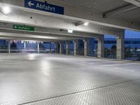 there is an empty parking garage with a sign in the ceiling above it and on the right corner, a bright light shines in the ground