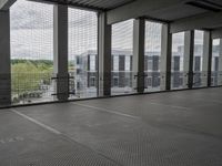 this is an empty floor in a building with large windows, as seen from behind the building