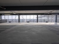a empty parking garage filled with lots of windows and lots of empty concrete flooring