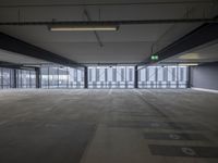 a empty parking garage filled with lots of windows and lots of empty concrete flooring