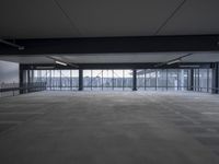 a empty parking garage filled with lots of windows and lots of empty concrete flooring
