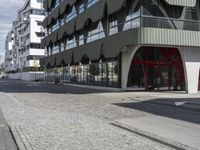 a paved city street next to a building on a sunny day next to a street