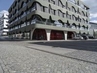 a paved city street next to a building on a sunny day next to a street