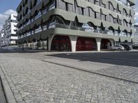 a paved city street next to a building on a sunny day next to a street