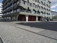 a paved city street next to a building on a sunny day next to a street