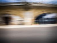 blurred view of the tunnel in motion, with car and building in background and blurry image to depict vehicle motion