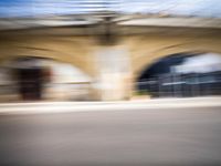 blurred view of the tunnel in motion, with car and building in background and blurry image to depict vehicle motion