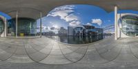 two round panoramas are all showing each other's reflections in the water, and some buildings in the background