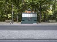 an empty street with benches sitting on top of it by the side walk next to trees