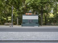 an empty street with benches sitting on top of it by the side walk next to trees