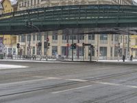 two people walking on the road by an overpass in the winter time, during a heavy snow storm