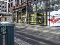 a street view of shops that are brightly lit in the morning sun with large glass windows