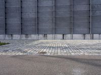 a fire hydrant is on the cement side of a building with steel grates