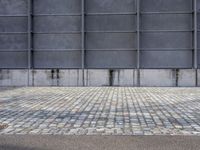 a fire hydrant is on the cement side of a building with steel grates