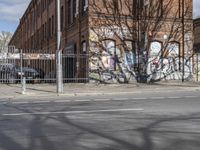 a motorcycle is parked on the side of the road beside a gate covered in graffiti