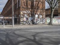 a motorcycle is parked on the side of the road beside a gate covered in graffiti