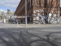 a motorcycle is parked on the side of the road beside a gate covered in graffiti