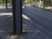 a small brick road is shown lined with trees and brick sidewalks on either side of the street