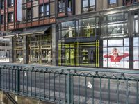 a bridge over a road in front of a store with lots of windows and large glass windows