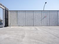 the empty parking lot is empty and concrete wall - like, which is a symbol of safety