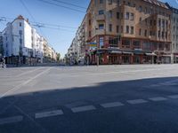 a street with two trains on it and a few people walking under an overpass