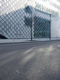 an image of a city street in the sun by a building and fenced in