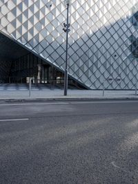 an image of a city street in the sun by a building and fenced in