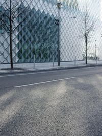 an image of a city street in the sun by a building and fenced in