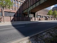 a skate board is in front of an empty road in front of a building with tall windows
