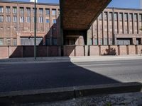 a skate board is in front of an empty road in front of a building with tall windows