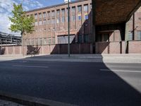 a skate board is in front of an empty road in front of a building with tall windows
