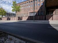 a skate board is in front of an empty road in front of a building with tall windows
