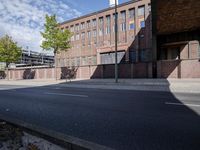 a skate board is in front of an empty road in front of a building with tall windows