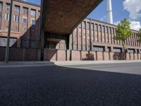 a skate board is in front of an empty road in front of a building with tall windows