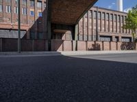 a skate board is in front of an empty road in front of a building with tall windows