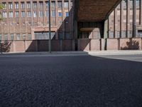 a skate board is in front of an empty road in front of a building with tall windows