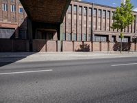 a skate board is in front of an empty road in front of a building with tall windows