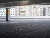 a view from an empty parking lot of an apartment complex at the edge of a parking lot