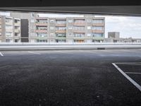 a view from an empty parking lot of an apartment complex at the edge of a parking lot