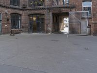 there is a bench at the entrance of this old warehouse building with steel gates and brickwork