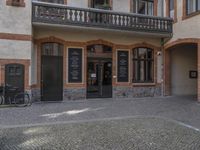 a cobble stone courtyard next to an empty building with the word kfc in german