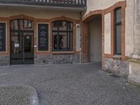 a cobble stone courtyard next to an empty building with the word kfc in german