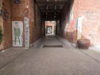 graffiti filled walkway in an alley way leading to the exit gate of a building with red brick walls