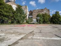 an empty basketball court in an abandoned city center area with graffiti on it and no people standing nearby