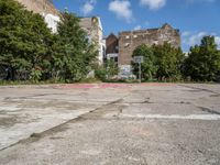 an empty basketball court in an abandoned city center area with graffiti on it and no people standing nearby