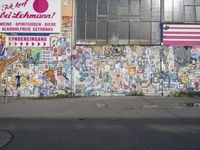 an image of graffiti on the side of a building with a flag in it, and a dog laying out on the sidewalk