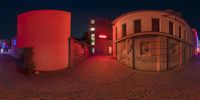 a 360 - view of an outside area with colorful lighting around the area with red buildings and blue lights