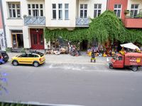 a group of cars parked in front of a building next to a street filled with motorcycles