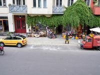 a group of cars parked in front of a building next to a street filled with motorcycles