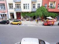 a group of cars parked in front of a building next to a street filled with motorcycles